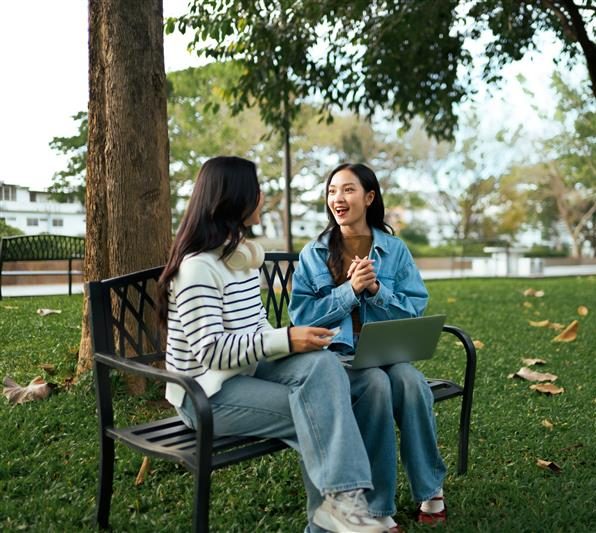two women sit and talk